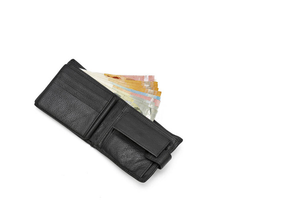Вид зверху Новий чорний справжній шкіряний гаманець з банкнотами та кредитною карткою всередині ізольовано на білому тлі
 - Фото, зображення