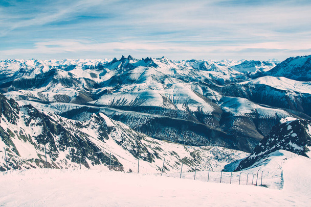 French Alps winter landscape. High peak snow background. Mountain covered with white snow. Sunny winter panoramic view. Ski and snowboard slope in tourist resort. - 写真・画像