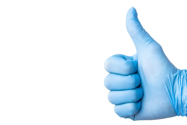 Символ схвалення. Рука в синій латексній рукавичці ізольована на білому, показуючи знак OK. Порожній медичний фон простору копіювання. Доктор успішна операція. Рукавички гігієни епідемії вірусів
. - Фото, зображення