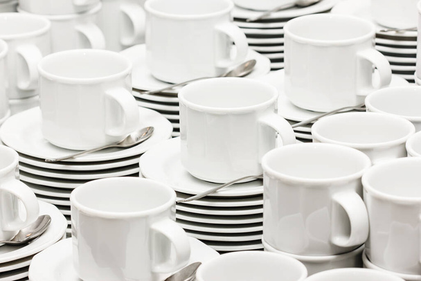 Catering company coffee table. Pile of white ceramic cups background. Small coffee mugs texture. - Photo, Image