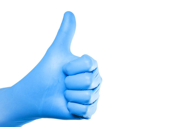 Daumen hoch. Hand in Hand in blauem Latex-Handschuh isoliert auf weiß mit OK-Zeichen. Leerer Kopierraum medizinischer Hintergrund. Arzt erfolgreich operiert. Hygienehandschuh für Virusepidemien. - Foto, Bild