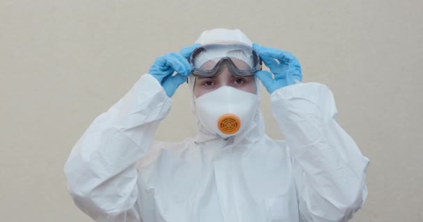 Takım elbiseli ve gözlüklü bir doktor. Maskeli Coronavirus COVID-19 hastalarını koruyan epidemiyoloji uzmanı portresi. Küresel salgın, Avrupa, İtalya, ABD - Video, Çekim