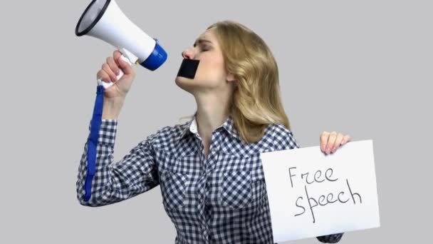Young woman tries to speak in megaphone with taped mouth. - Metraje, vídeo