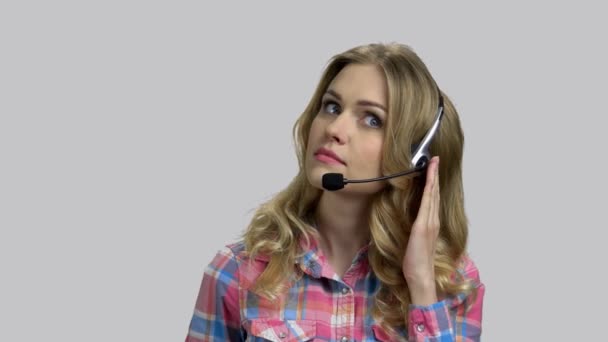 Junge Betreiberin mit Headset hilft Kunden bei Hotline. - Filmmaterial, Video