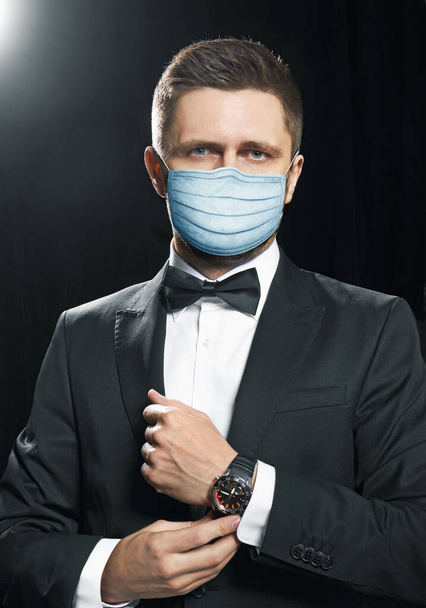 Άνδρας με μαύρη σουίτα σε μάσκα προστασίας, για πρόληψη από τον ιό covid-19 - Φωτογραφία, εικόνα