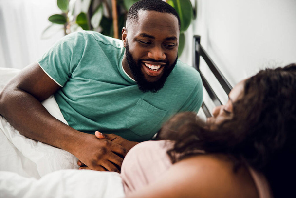 Positive man in bed with his woman stock photo - Fotó, kép