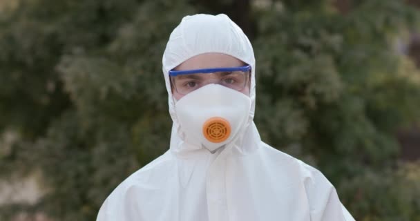 Close up portrait of virologist worker in protective suit, goggles and respirator. Covid-19 coronavirus epidemic spreading prevention, USA, Italy, Europe - Video
