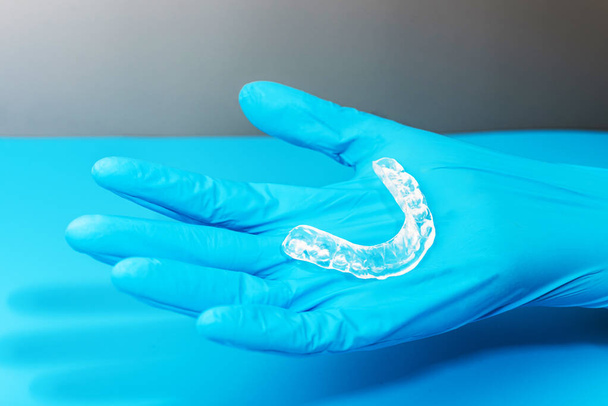 Zahnarzt hält Okklusalschiene in der Hand, um nächtlichen Bruxismus zu reduzieren. - Foto, Bild
