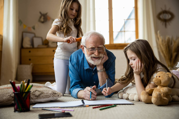Happy elderly man drawing with kids stock photo - Photo, Image