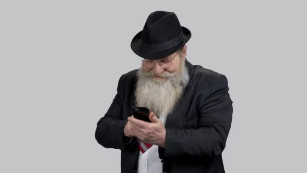 Viejo hombre feliz muestra el pulgar hacia arriba a alguien en línea usando su teléfono
. - Metraje, vídeo