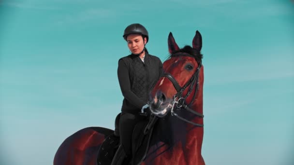 Equitación - hermosa jinete mujer con una postura recta se sienta a horcajadas a caballo
 - Metraje, vídeo