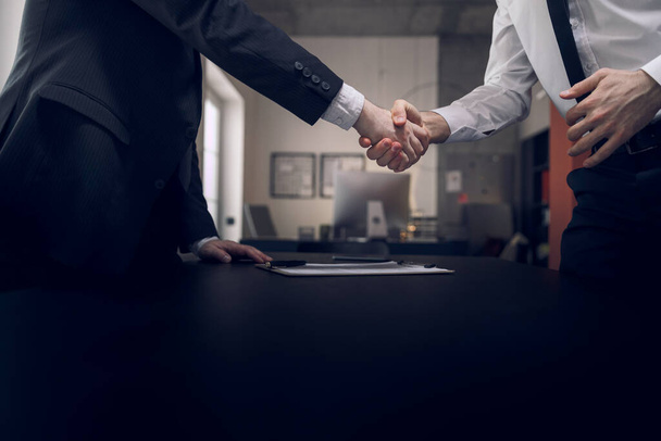 Men are shaking hands after meeting in office - Foto, Imagen