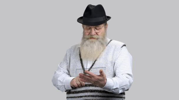 Старый бородатый человек прокручивает и крадет прозрачный планшет копирайта стекла
. - Кадры, видео