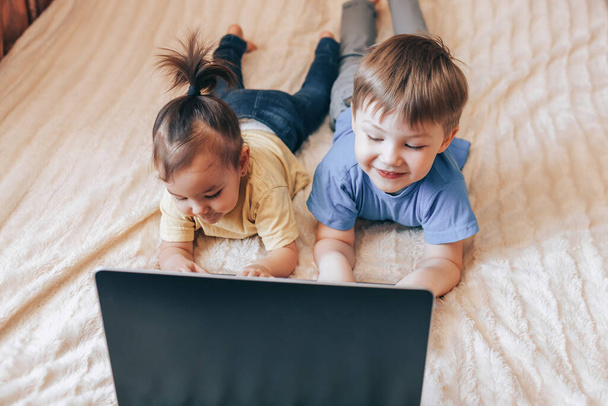 Crianças sorridentes usando um laptop
 - Foto, Imagem