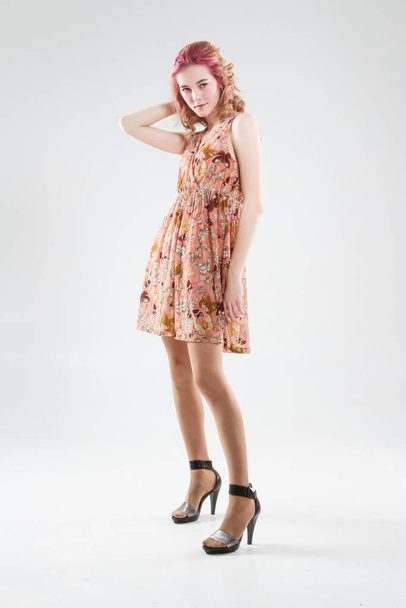 Young blonde in a short summer dress. Studio portrait on a white background. - Photo, Image