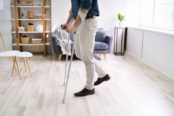 Disabled Man Using Crutches To Walk At Home - Fotoğraf, Görsel