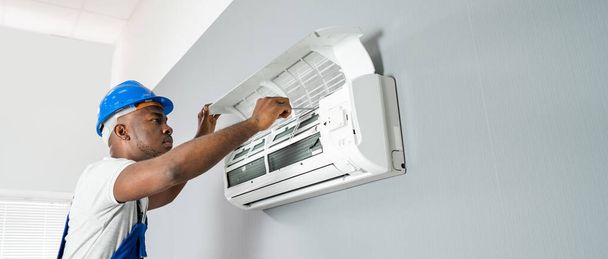 Happy Young African Male Technician Repairing Air Conditioner - Photo, Image