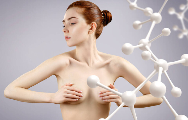 Mujer desnuda joven cubre pechos entre las moléculas de vidrio de la cadena
. - Foto, Imagen
