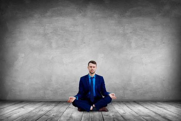 Hombre de negocios tranquilo sentado en pose de loto y meditando
. - Foto, Imagen