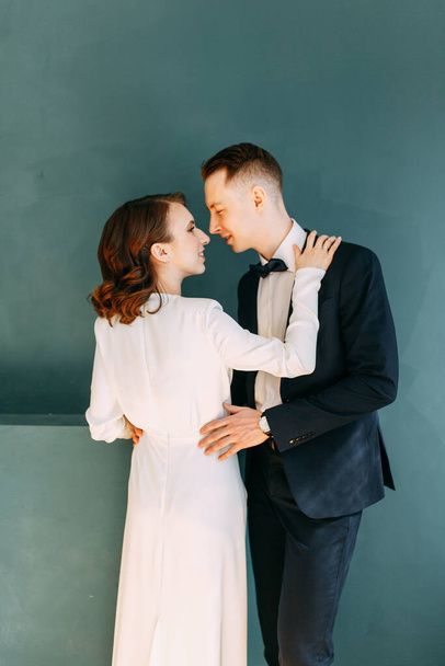 The bride and groom's romantic photo shoot. The newlyweds are happy together. Stylish modern couple in an interior Studio.  - Fotó, kép