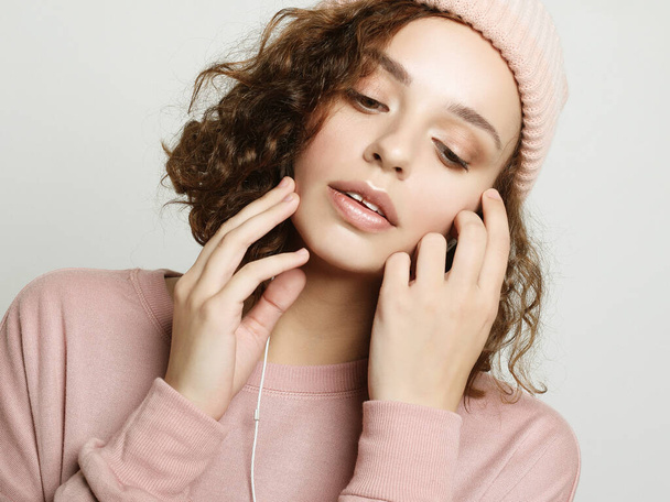 lifestyle and people concept: Beautiful young curly woman in headphones listening to music smiling with closed eyes - Фото, изображение