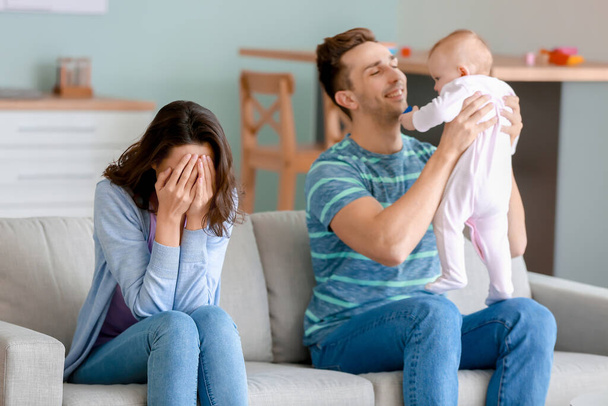 Père heureux avec son bébé et sa femme souffrant de dépression postnatale à la maison
 - Photo, image