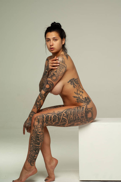 young girl with tattoo pose nude in studio - 写真・画像