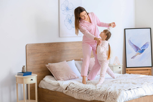 A boldog anya reggele és a kislánya táncol a hálószobában - Fotó, kép