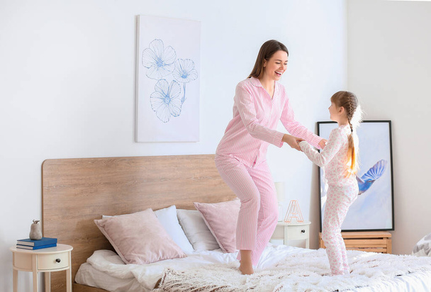 Morning of happy mother and her little daughter dancing in bedroom - Foto, imagen