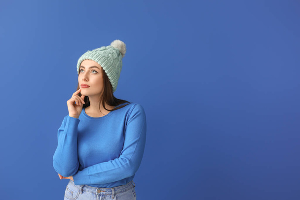 Young woman in warm sweater on color background - Photo, Image