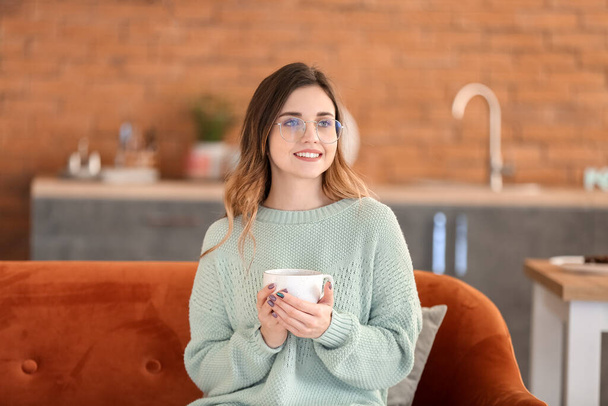 Giovane donna in maglione caldo bere tè a casa
 - Foto, immagini