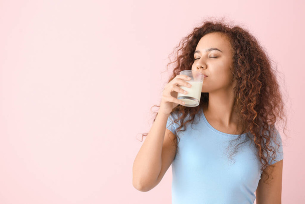 Mujer afroamericana con leche sobre fondo de color
 - Foto, imagen