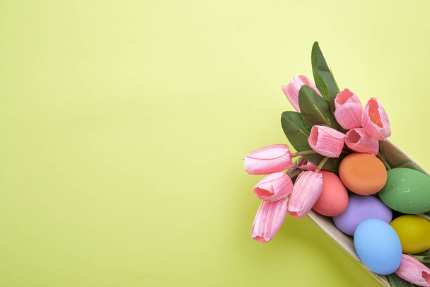 Pink tulips in box and Egg Easter on paper yellow background copy space for text - 写真・画像