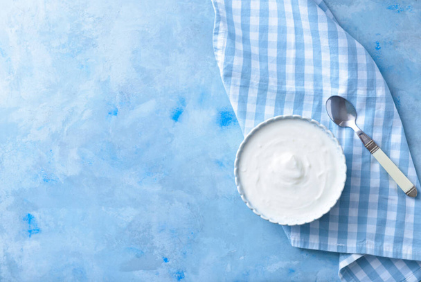 Bowl with tasty yogurt on color background - Фото, изображение