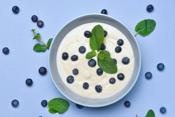 Ciotola con gustoso yogurt e bacche su sfondo a colori
 - Foto, immagini
