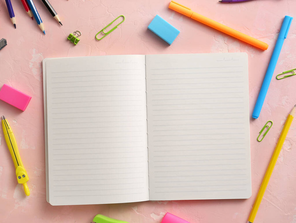 Cuaderno con material escolar sobre fondo de color
 - Foto, imagen