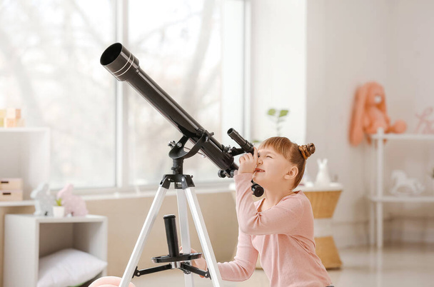 Cute little girl with telescope at home - Foto, imagen