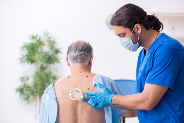 Old man visiting young male doctor dermatologist - Photo, Image