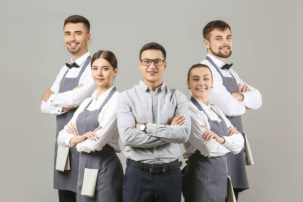 Group of waiters with teacher on grey background - Photo, Image