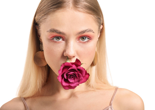 Young woman with beautiful makeup and flower on white background - Photo, Image