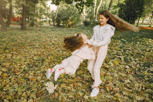 Cute little sisters plauing in a spring park - Photo, image