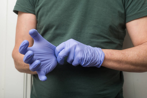 Крупный план рук врача в латексных перчатках для защиты от пандемии коронавируса
 - Фото, изображение