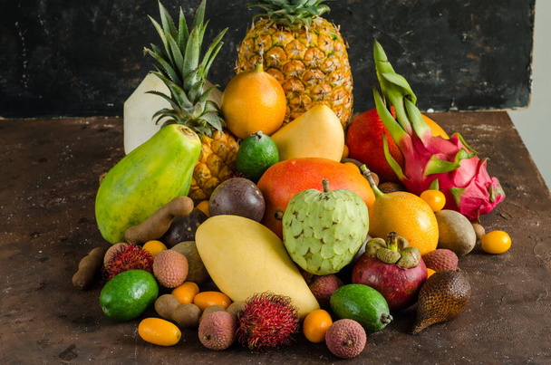 Healthy eating, varieity of tropical fruits on a dark background. - Φωτογραφία, εικόνα