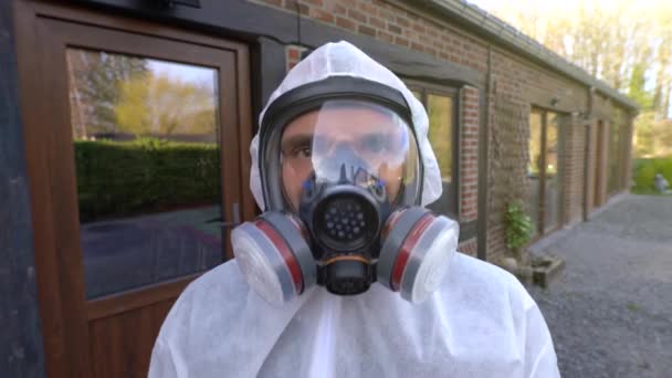 L'uomo che indossa una maschera respiratoria completa e una tuta bianca che mostra segni di si '. Pandemia e blocco di coronavirus covid-19 SARS-CoV-2 in tutto il mondo
. - Filmati, video