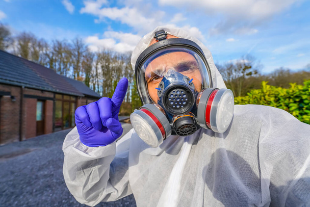 Людина у великій газовій масці проти забруднення Коронавірусу Ковід-19. Lockdown для пандемії вірусу SARS-CoV2. Спеціаліст з апокаліпсису дихає антивірусом і радіаційною маскою. Судний одяг - Фото, зображення