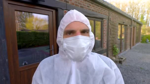 Doctor wearing antiviral protective surgical face mask and coveralls showing no sign. Coronavirus pandemic worldwide crisis and lockdown in Europe, USA and China. Dangerous SARS-CoV-2 virus Epidemic. - Кадры, видео