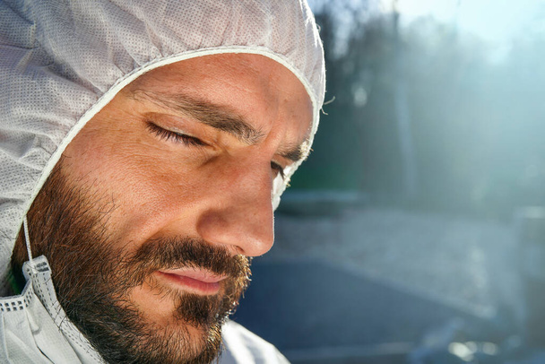 Dokter draagt antivirale beschermende chirurgische gezichtsmasker en overall tijdens Coronavirus pandemie wereldwijde crisis en vergrendeling in Europa, de VS en China. Gevaarlijke SARS-CoV-2 virus Epidemic. - Foto, afbeelding