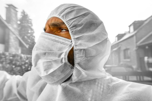 Doctor wearing antiviral protective surgical face mask and coveralls during Coronavirus pandemic worldwide crisis and lockdown in Europe, USA and China. Dangerous SARS-CoV-2 virus Epidemic. - Фото, зображення