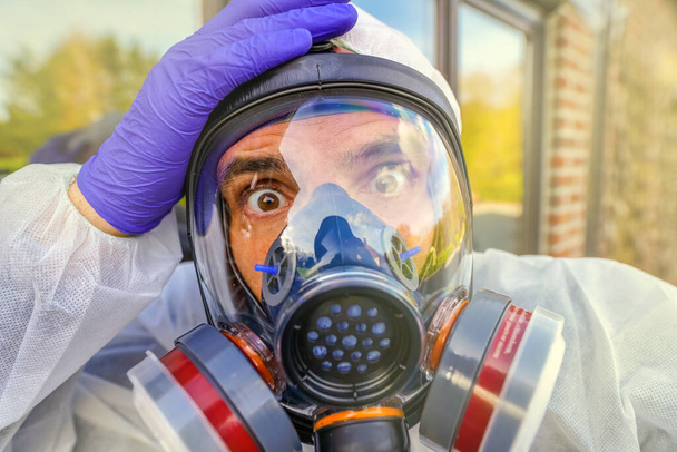 Людина у великій газовій масці проти забруднення Коронавірусу Ковід-19. Lockdown для пандемії вірусу SARS-CoV2. Спеціаліст з апокаліпсису дихає антивірусом і радіаційною маскою. Судний одяг - Фото, зображення