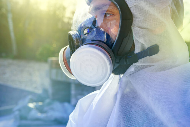 Homem com uma grande máscara de gás contra a contaminação pelo Coronavirus Covid-19. Bloqueio da pandemia do vírus SARS-CoV2. Especialista pós apocalipse respirando em anti-vírus e máscara de gás de radiação. Roupas do Juízo Final
 - Foto, Imagem